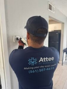 HVAC technician replacing a wall-mounted thermostat