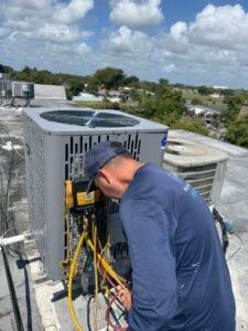 HVAC technician working on an air conditioning unit on a rooftop